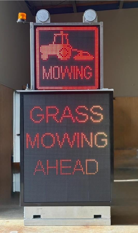 Advanced warning VMS board displaying grass mowing ahead