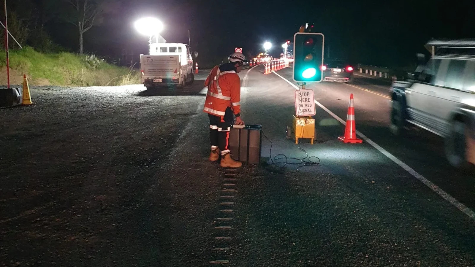 Night roadworks site using portable traffic lights and temporary worksite lighting