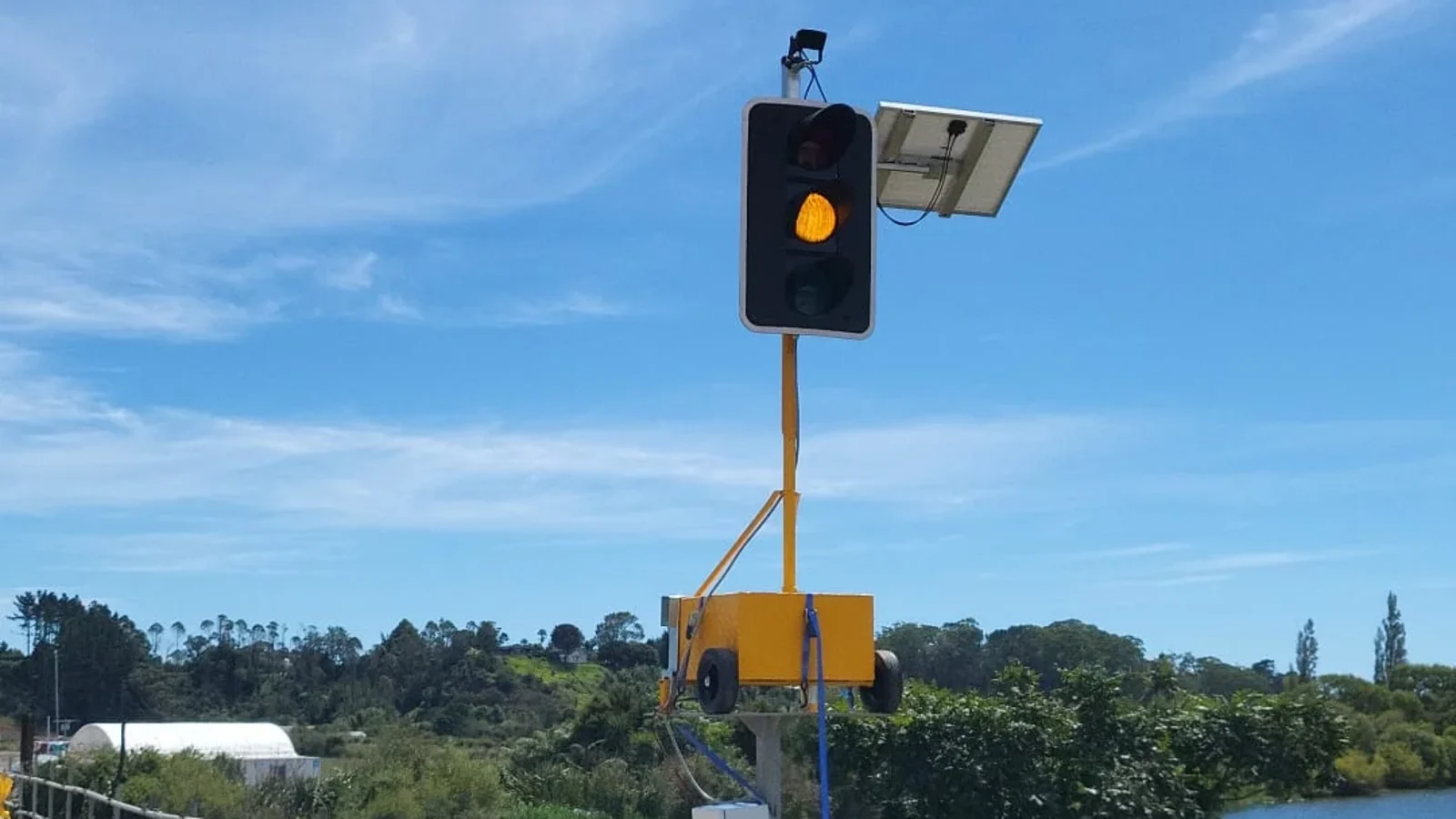 Solar powered portable traffic light beside concrete barriers near water