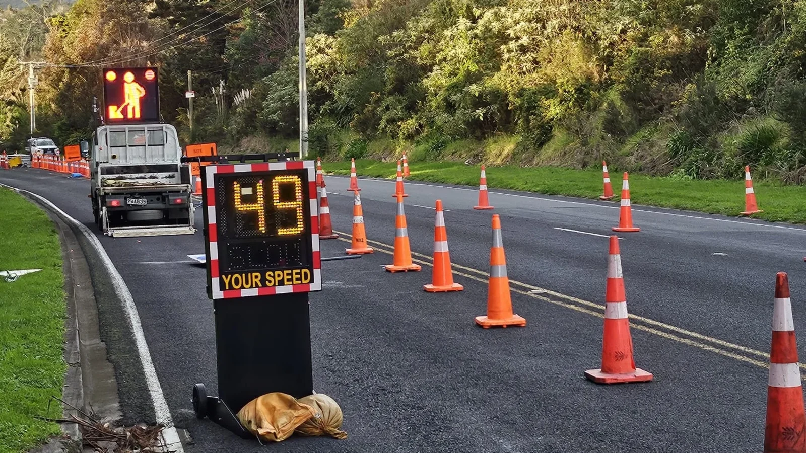 Temporary speed sign and roadworks warning board deployed on a rural road